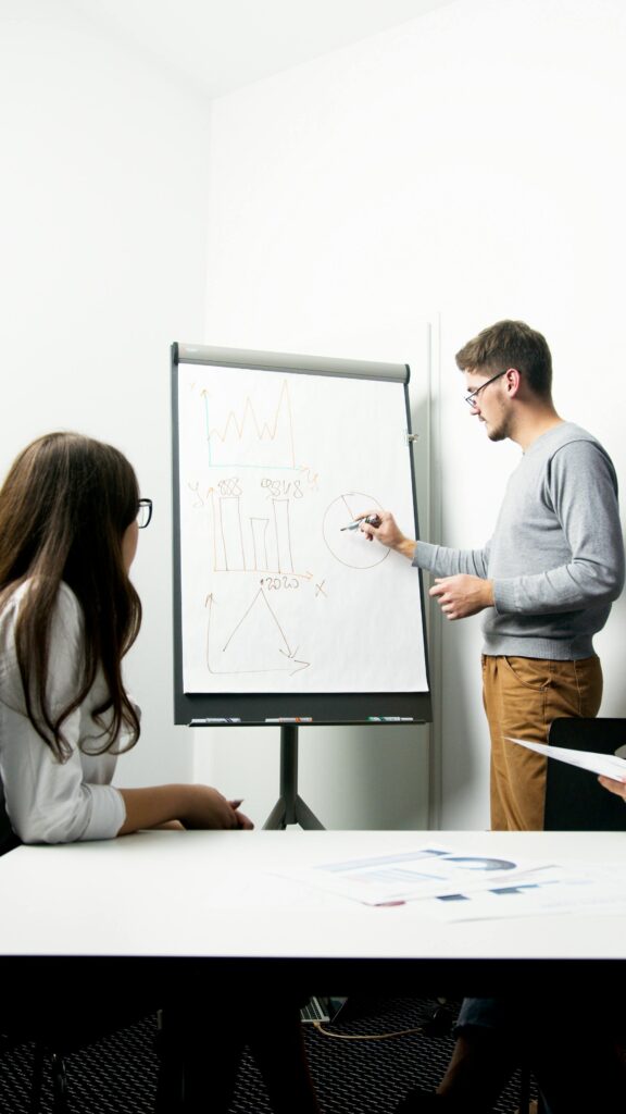 pexels-photo-5715847-5715847 A businessperson giving a presentation with charts in a modern office environment.